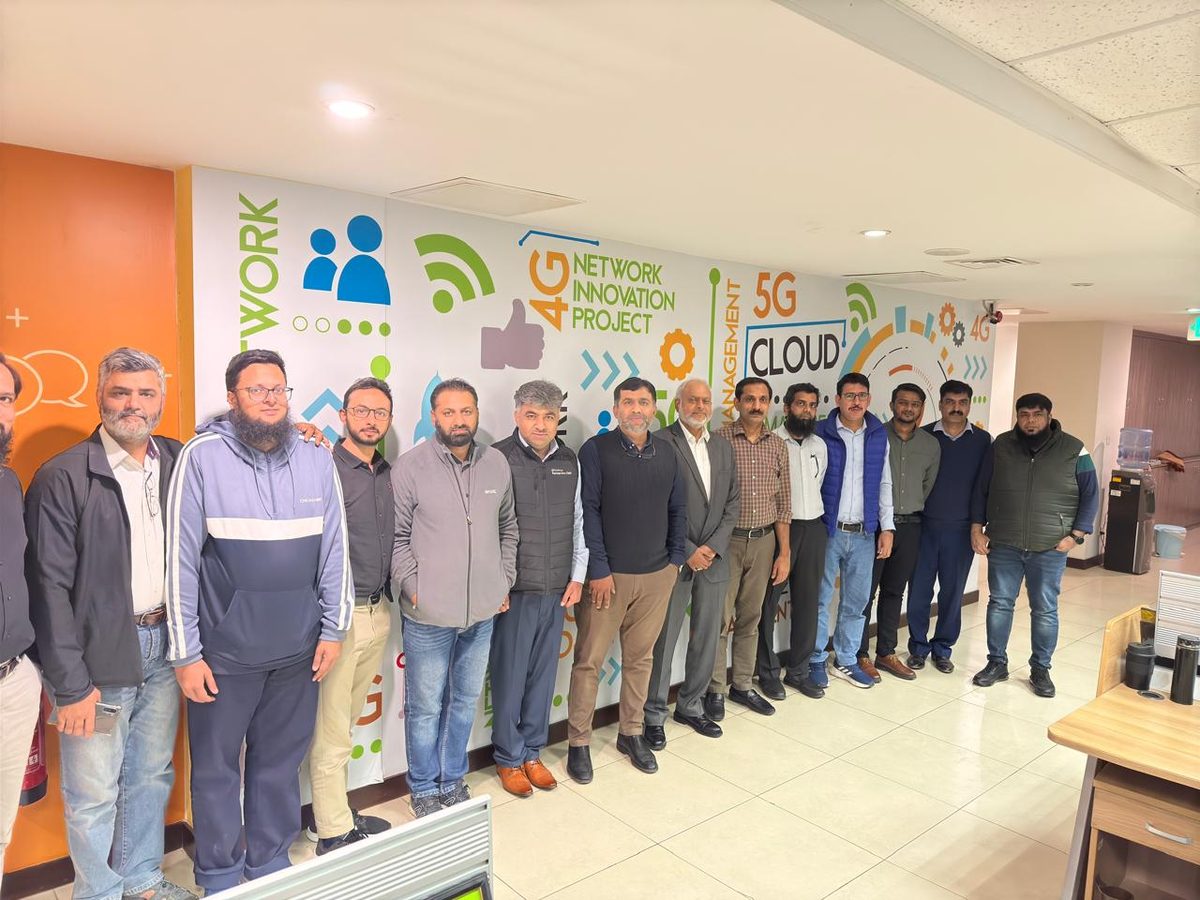 Team photo in front of the Network Innovation Project wall